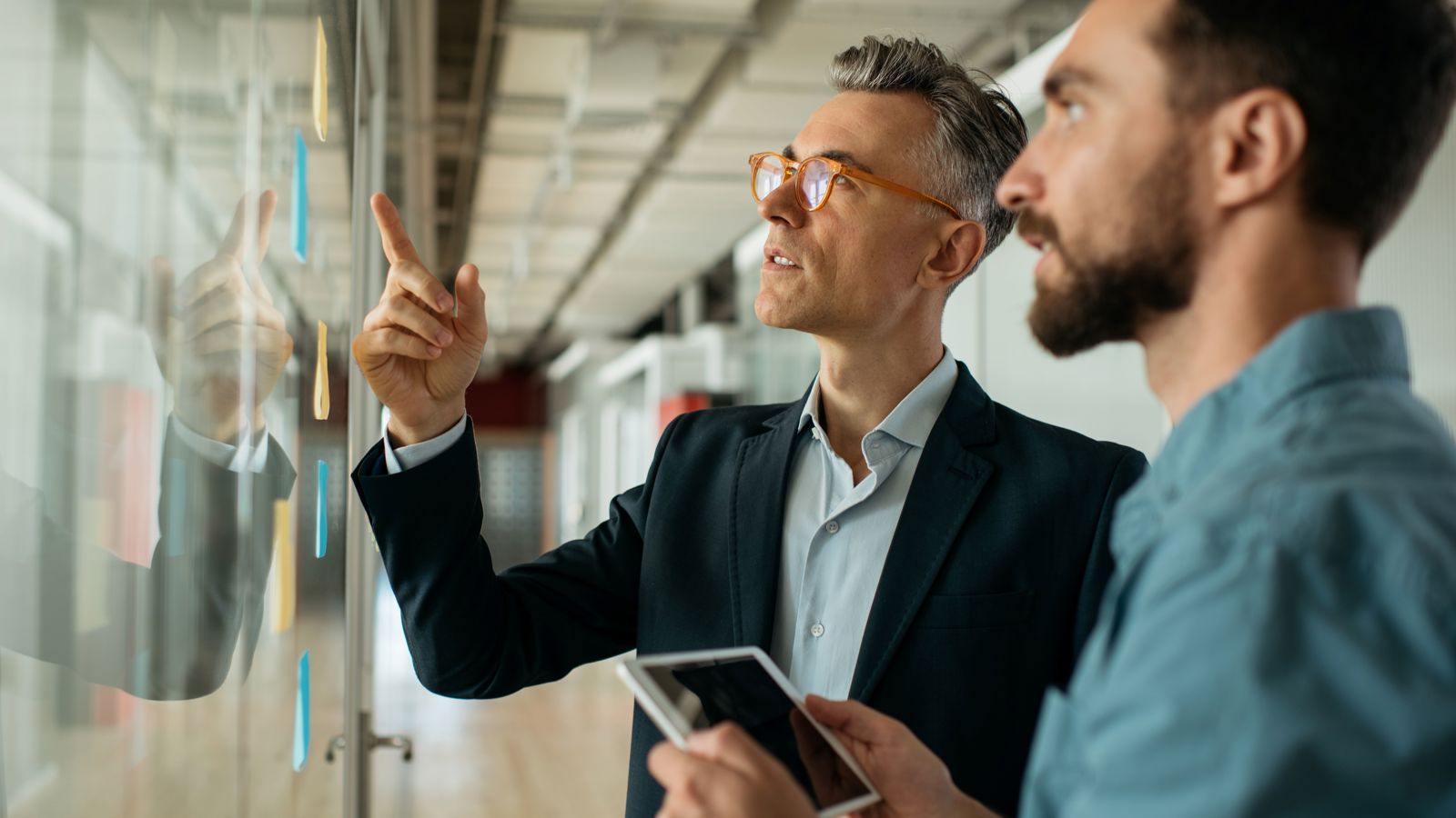 Two men looking at a whiteboard