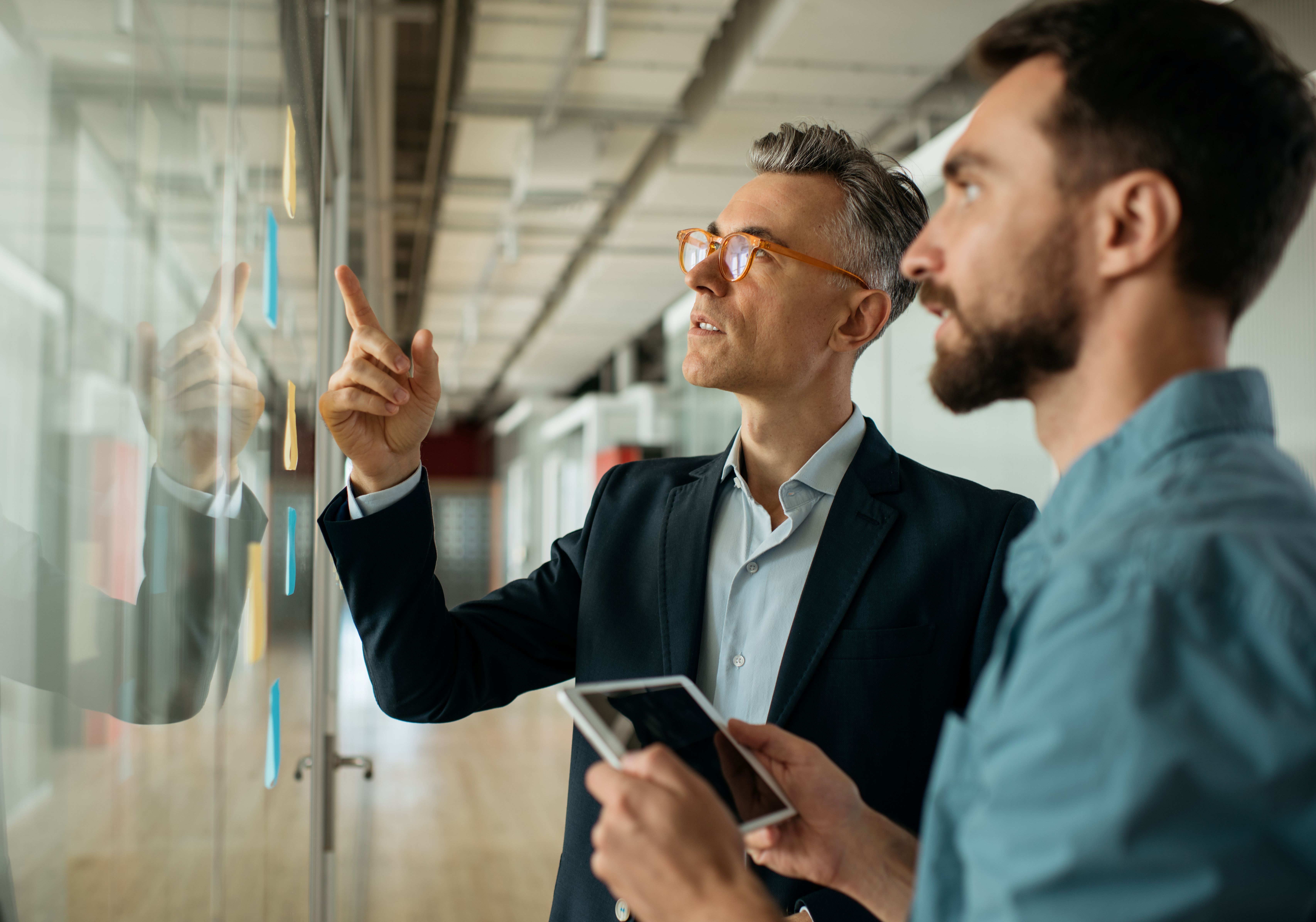 Two men looking at a whiteboard